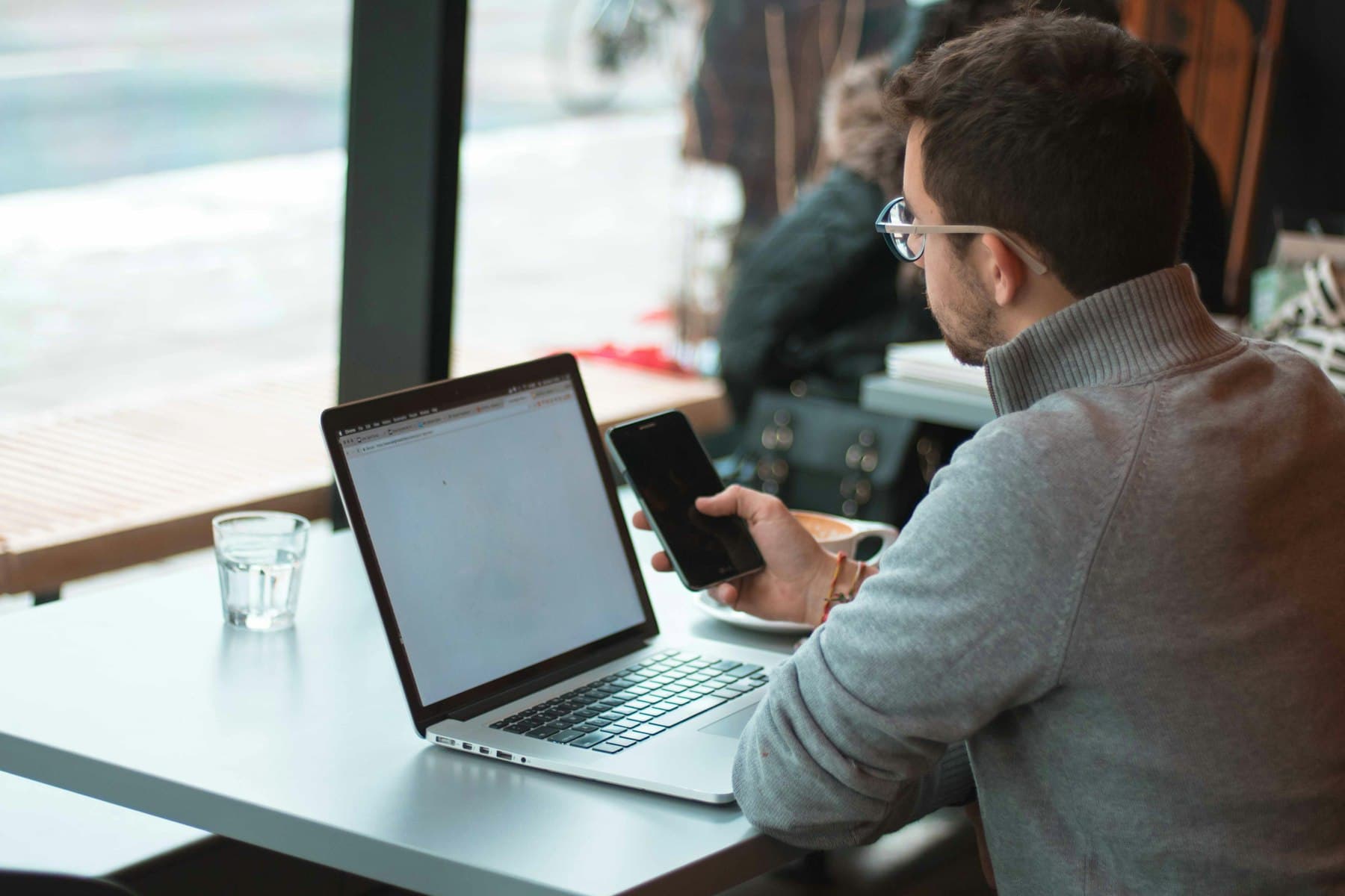A consultant working on a laptop by a window